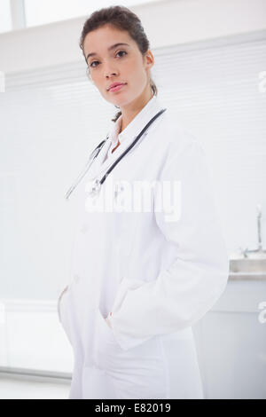 Concentrated doctor standing with stethoscope Stock Photo