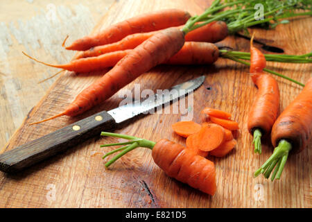 Cutted carrots with knife on a wooden board Stock Photo