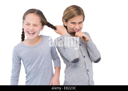 Angry young boy pulling sister hair in a fight Stock Photo