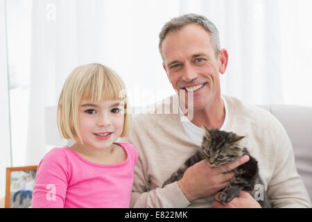 Happy daughter and father sitting with pet kitten together Stock Photo
