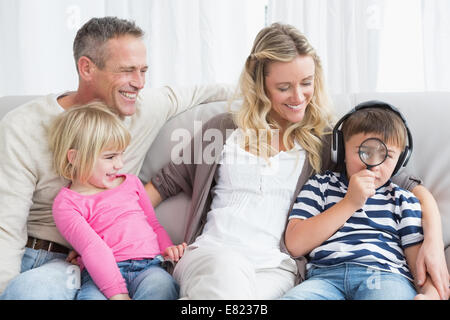 Son looking through magnifying glass Stock Photo