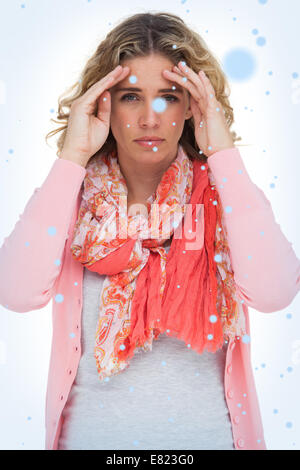Blonde woman touching her temples because of a headache Stock Photo