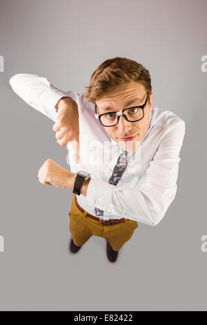 Geeky businessman pointing to watch Stock Photo