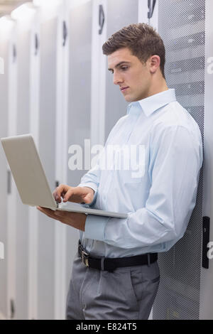 Focused technician typing on his notebook Stock Photo