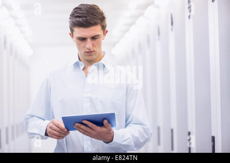 Concentrating young technician working with his tablet Stock Photo