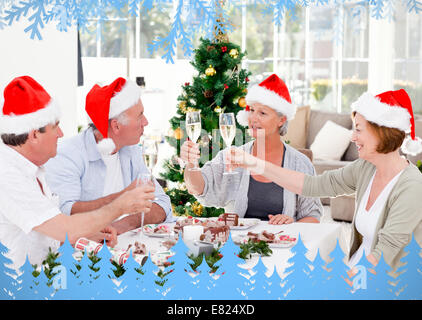 Family toasting a nice meal with frost and fir trees in blue Stock Photo