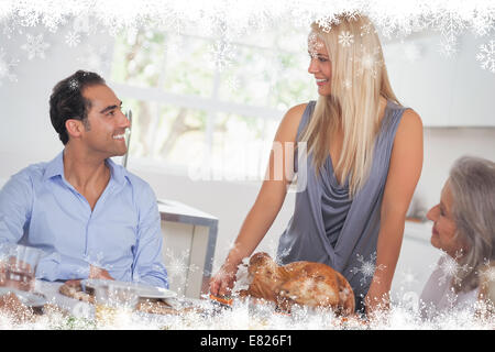 Composite image of happy wife bringing turkey to the table Stock Photo