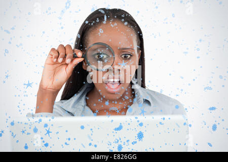 Businesswoman using a magnifying glass to look at her notebook Stock Photo