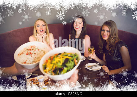 Composite image of happy friends looking at the salad Stock Photo