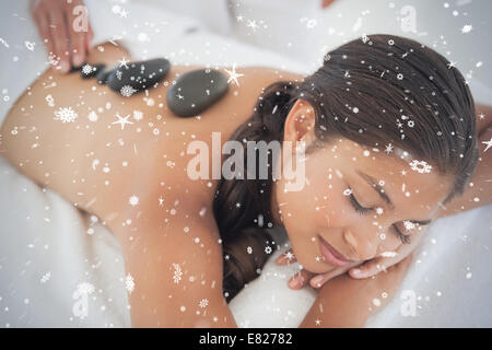 Beautiful brunette enjoying a hot stone massage Stock Photo