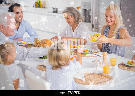 Composite image of happy family eating the thanksgiving dinner Stock Photo