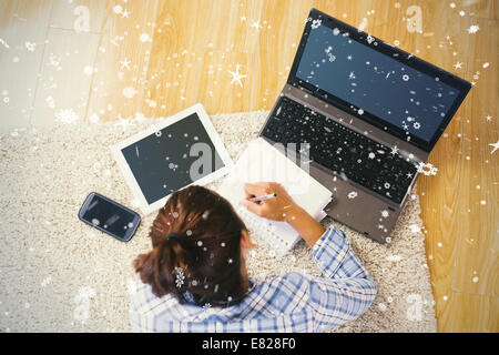 Brunette young student using her tablet and notebook for doing homework Stock Photo