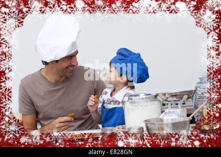 Smiling father and son eating homemade cookies Stock Photo
