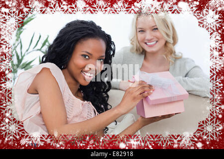 Woman holding a pink box smiles at the camera with her friend Stock Photo
