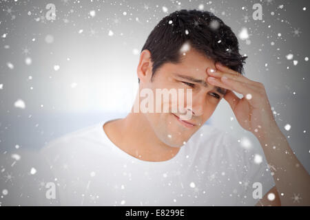 Worried man having a headache sitting in his bedroom Stock Photo