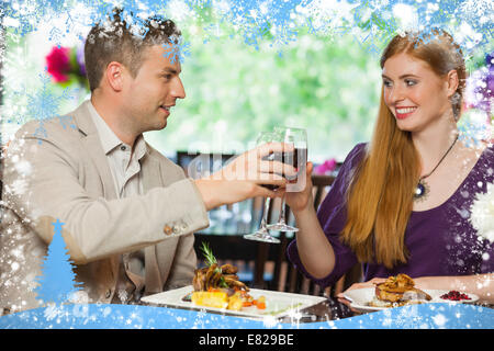 Composite image of cheerful couple having dinner together Stock Photo