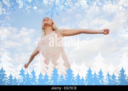 Young woman in summer dress stretching arms against sky Stock Photo