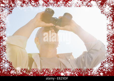 Happy hiker looking through binoculars Stock Photo