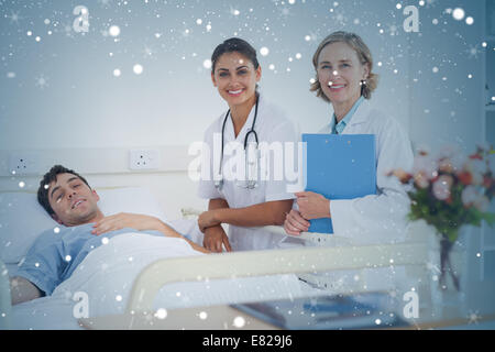 Composite image of two doctors and a patient looking at the camera Stock Photo
