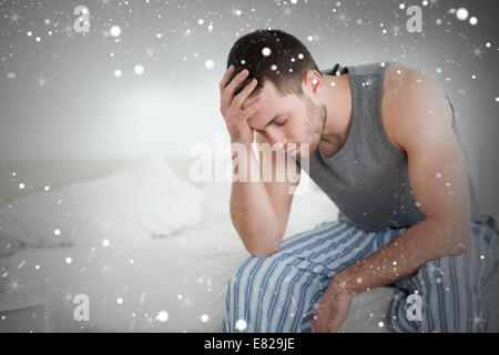 Composite image of exhausted man sitting on his bed Stock Photo