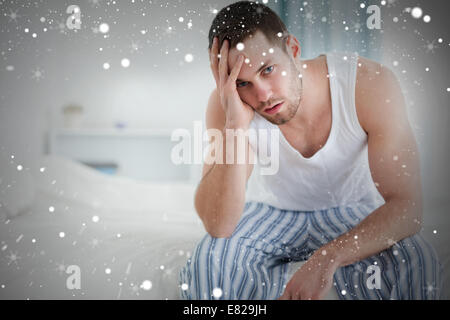 Composite image of depressed man sitting on his bed Stock Photo