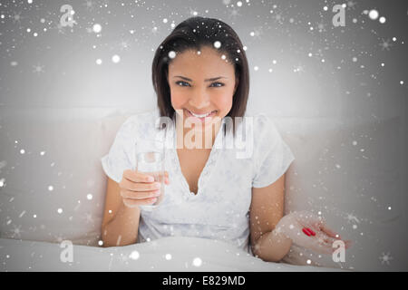 Composite image of content young dark haired model taking medication Stock Photo
