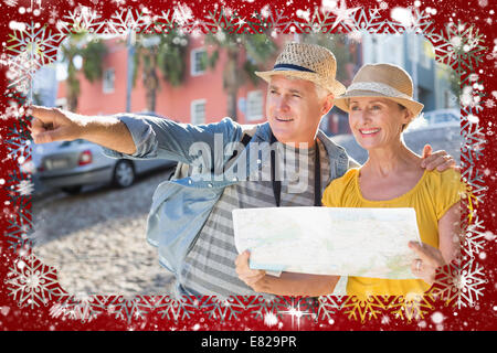Happy tourist couple using map in the city Stock Photo