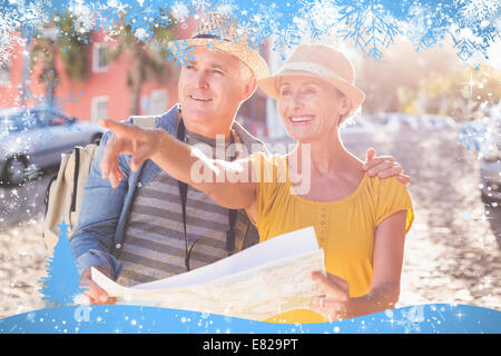 Happy tourist couple using map in the city Stock Photo
