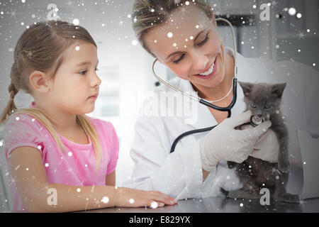 Composite image of female veterinarian examining kitten Stock Photo