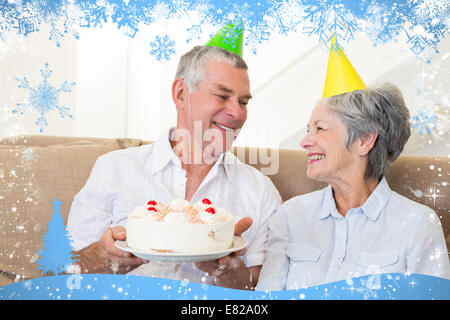 Senior couple sitting on couch celebrating a birthday Stock Photo