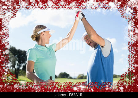 Golfing couple high fiving on the golf course Stock Photo
