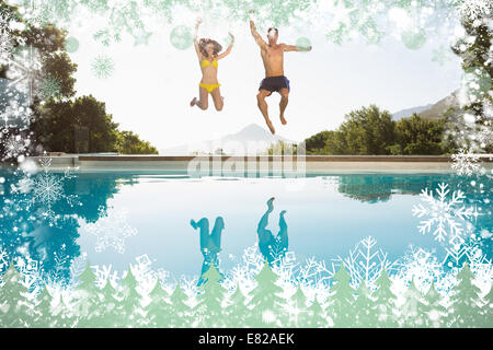 Cheerful couple jumping into swimming pool Stock Photo