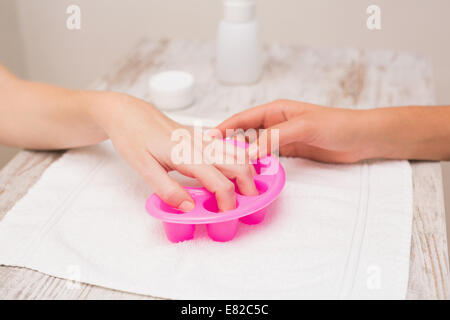 Woman soaking her nails in nail bowls Stock Photo