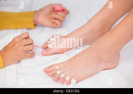 Womans toenails being painted by beautician Stock Photo