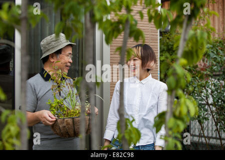 A man and a woman standing in their garden. Stock Photo
