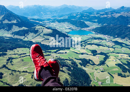 Feet of a paraglider pilot flying over Walchsee, Kaiserwinkl, Tirol , Austria Stock Photo