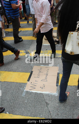 Hong Kong, 29 Sep, 2014. Hong Kong Protests: 'Wir kaempfen fuer Demokratie!' or 'We're fighting for Democracy!'. Sign in German put down by pro-democracy 'Umbrella Revolution' demonstrators blocking the main road outside Sogo Department Store on Hennessy Road in Causeway Bay, Hong Kong. The pedestrian crossing is one of the busiest in the world for footfall. Credit:  Robert SC Kemp/Alamy Live News Stock Photo