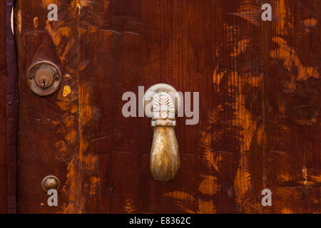 Brass hand door knocker and yale lock detail on old wooden door in Garachico, Tenerife, Canary Islands, Spain. Stock Photo