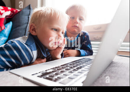 Serious little boys looking at computer screen Stock Photo