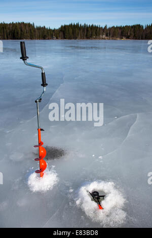 https://l450v.alamy.com/450v/e83bd8/isolated-hand-ice-auger-and-tip-up-ice-fishing-rod-at-frozen-lake-e83bd8.jpg