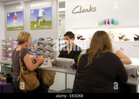 People paying for shoes at the counter checkout,  Clarks Shoe Shop, UK Stock Photo