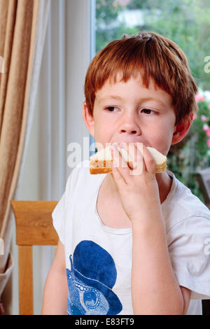 A young boy taking a bite out of a sandwich Stock Photo