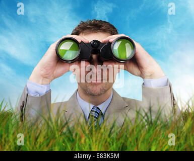 Businessman looking through binoculars Stock Photo