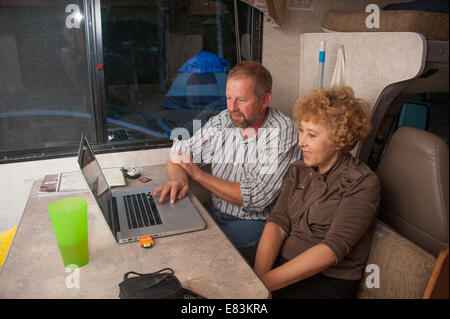 Man and woman looking at computer screen in RV Stock Photo