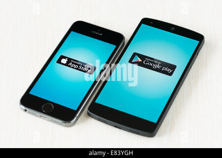 Close-up shot of brand new Apple iPhone 5S and Google Nexus 5 smartphones with App Store and Google Play logos on a screen. Stock Photo