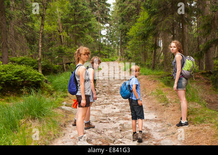 Mother with her three children are  walking down the path in  the  Stolowe mountains. Poland. Stock Photo