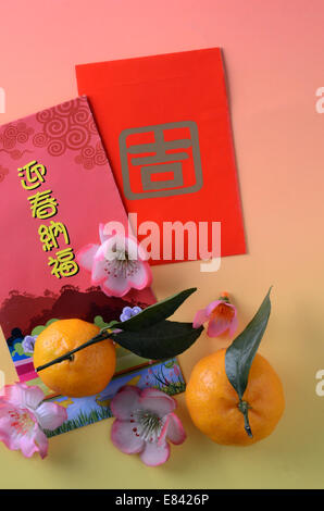 Auspicious red packets with Chinese New Year greeting and two tangerines Stock Photo