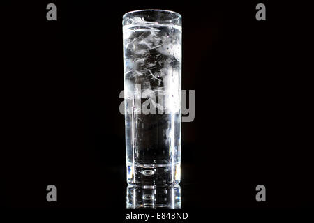 A glass of clear drinking water from a tap against a black background. Stock Photo
