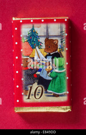 Count down to Christmas with individual advent chocolate bars isolated on red background - calendar day 10 of set of 24 Stock Photo