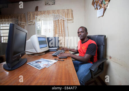 Rwandan website administrator running an online business from his home office, Kigali, Rwanda Stock Photo